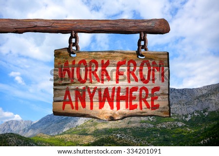 Work from anywhere motivational phrase sign on old wood with blurred background