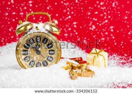 vintage christmas decoration golden star and antique golden clock in snow on red background