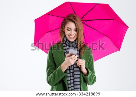 Portrait of a smiling woman using smartphone under umbrella isolated on a white background