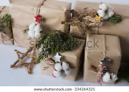 Christmas gift boxes with flowers and decorative objects Eco cotton, cinnamon, spruce branches and jute rope hank over white background,holiday,xmas,christmas