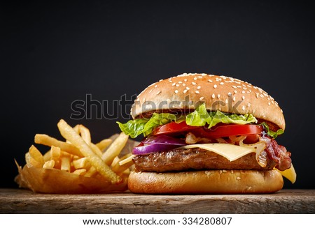fresh tasty burger and french fries on wooden table Royalty-Free Stock Photo #334280807