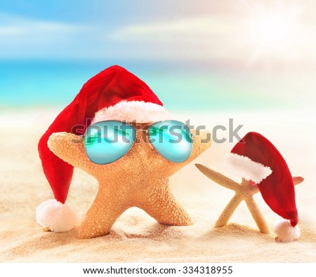 Starfish in sunglasses on summer beach and santa hat. Merry Christmas