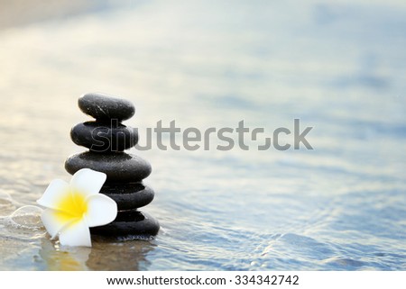 Composition of pebbles and fragipani flower
