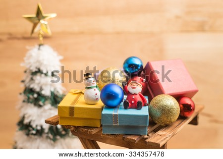 Christmas's present box with ornament and santa claus doll on wood background for ceremony, x'mas, christmas, newyears holidays uses purpose (selective focus technique applied)