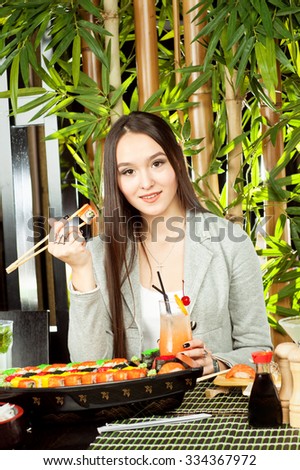 Sushi woman holding sushi with chopsticks