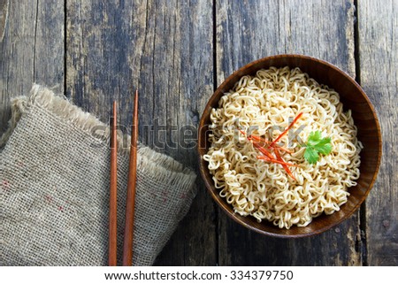 Instant noodles in wooden bowl on wood background 