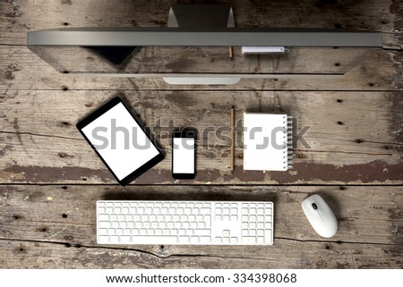 computer desk with desktop computer phone, tablet, notepad, keyboards and mouse on wooden table