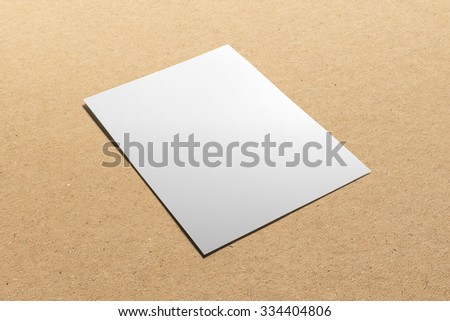 Blank flyer, leaflet isolated on cardboard background, with clipping path, changeable background