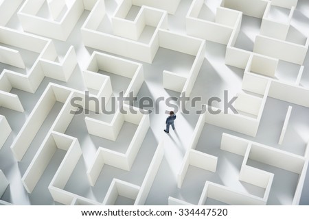 Business challenge. A businessman navigating through a maze. Top view Royalty-Free Stock Photo #334447520