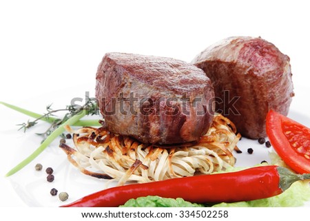grilled beef fillet with thyme , red hot chili pepper and tomato on plate isolated over white background