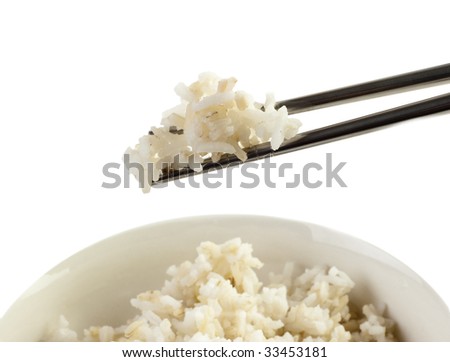 A bowl of cooked brown rice, in an Asian style bowl, with chopsticks isolated on white.