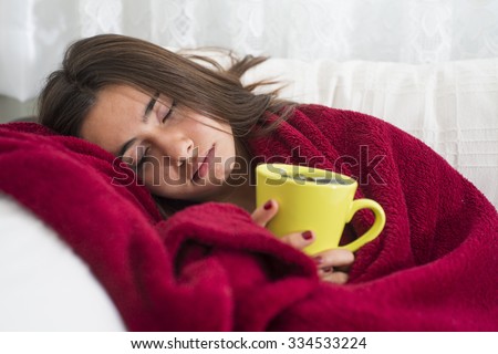 ill young girl with fever drinking cup of warm tea Royalty-Free Stock Photo #334533224