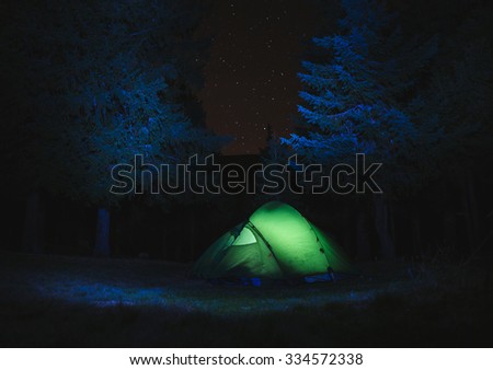 illuminated Tent with stars and Mountains in the background