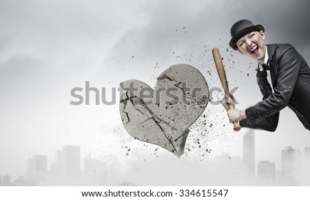 Young emotional woman in suit and hat with baseball bat