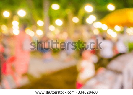 image of blurred background  night market on street decorated with festive lights .