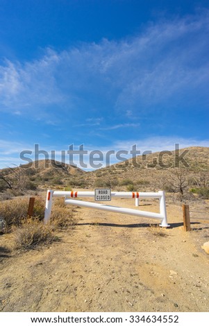 White gate marks a closed road that leads into the Mojave desert Californian wilderness.