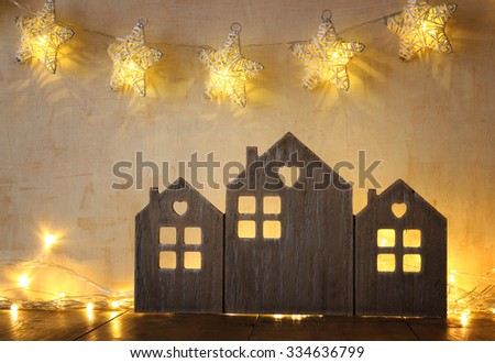 low key and abstract filtered image of vintage wooden house decor on wooden table and stars garland. selective focus