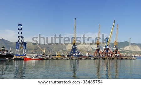 Panorama of quay and port with a mountain landscape and many hosting cranes, the city of Novorossisk, Russia