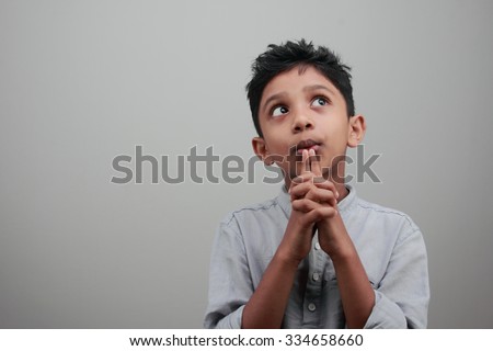 Portrait of a boy looks up and thinks deep Royalty-Free Stock Photo #334658660