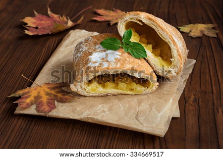Strudel with a pear on a wooden table