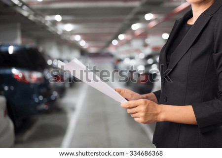 Businesswoman in Underground parking with cars.
