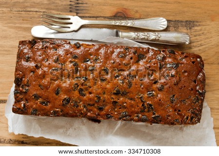 English fruit cake on white paper on brown wooden background
