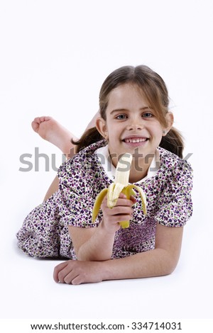 Girl, aged four, with one banana in his hands, looking at the camera smiling
