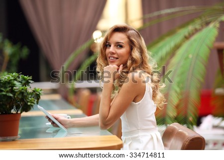 Beautiful young woman with digital tablet in cafe
