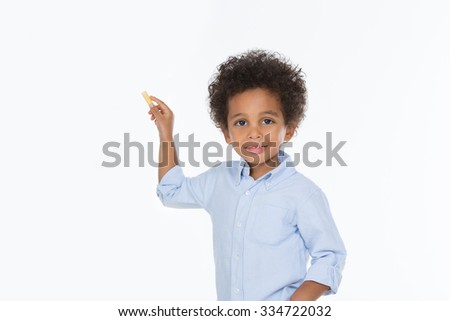 little child looking at the camera holding a yellow chalk