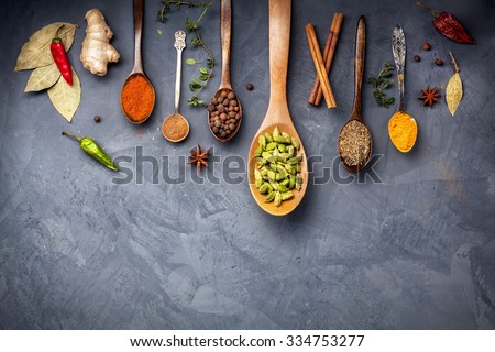 Various Spices like turmeric, cardamom, chili, bayberry, bay leaf, ginger, cinnamon, cumin, star anise on grunge background with space for your text Royalty-Free Stock Photo #334753277