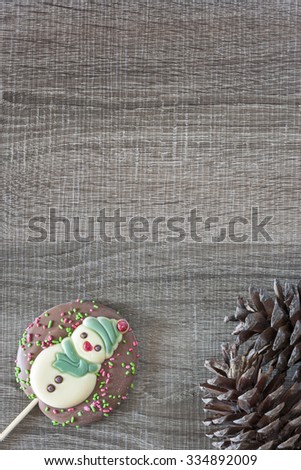 Christmas frame with chocolate snowman on a wooden background
