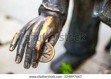 Sculpture hand with coin