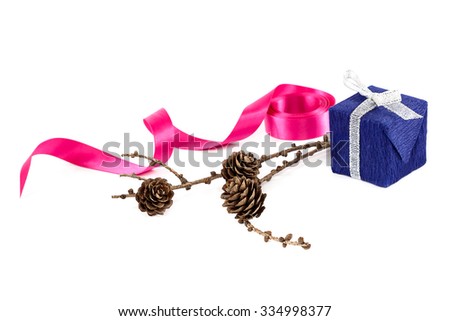Holiday gift, pink ribbon and a branch of pine tree with cones isolated on white background.