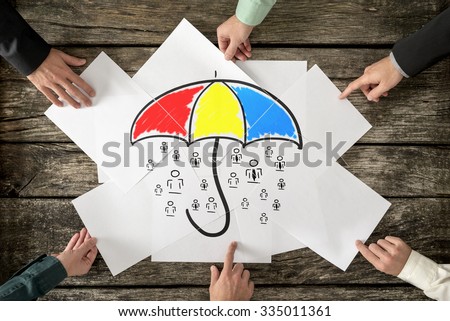 Safety and life insurance concept - six hands assembling a colourful umbrella sheltering many people icons drawn on white papers. Royalty-Free Stock Photo #335011361