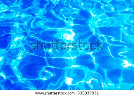 Swimming pool blue water reflecting the sun rippled details.