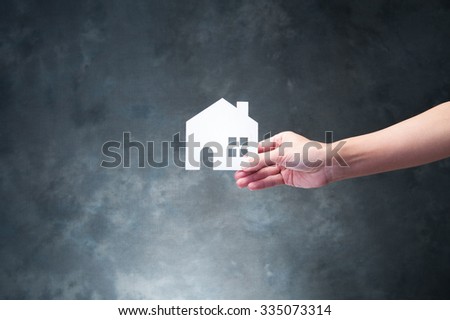 Hand holding a model of house