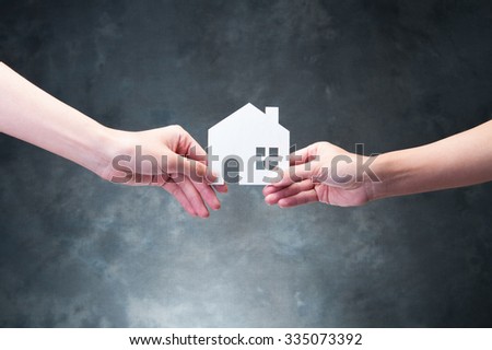 Hand holding a model of house