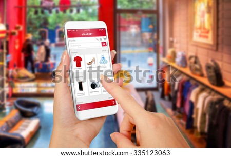 Smart phone online shopping in woman hand. Shopping center in background. Buy clothes shoes accessories with e commerce web site Royalty-Free Stock Photo #335123063