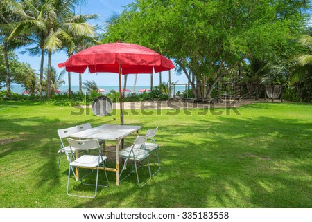 Bench with table on green grass near the beach