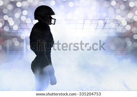 Side view of silhouette American football player standing against glowing background