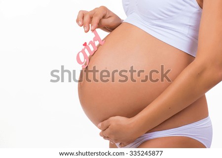Close-up of pregnant tummy with pink label "Girl" for newborn daughter on  horizontal white background