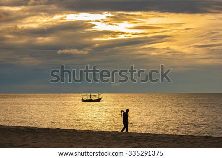 Silhouette photographer walking on the beach at Sam Phraya Beach, Khao Sam Roi Yot National Park, Thailand