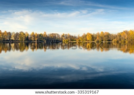 Picture of a lake and trees with colorful leaves on an evening in autumn in Bavaria