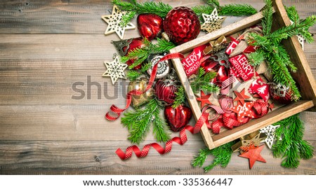 Christmas decorations and ornaments with christmas tree branches. Red stars, baubles, ribbons. Vintage style toned picture