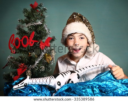 preteen handsome boy with christmas tree and present smiling