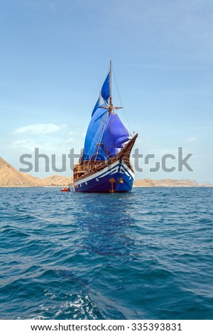 Vintage Wooden Ship with Blue Sails near Komodo Island, Indonesia