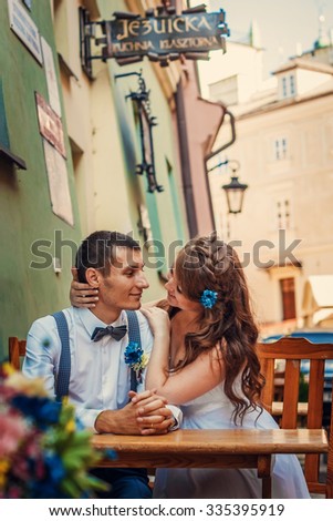 Wedding photo: the bride and groom on a walk sitting in a cafe in the old town