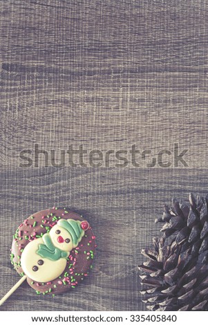 Christmas frame with chocolate snowman on a wooden background