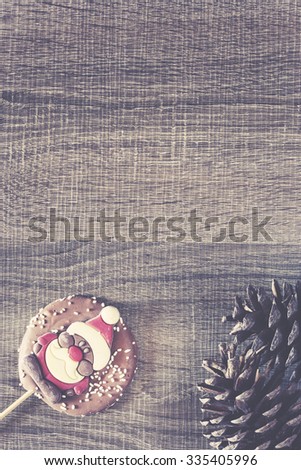 Christmas frame with chocolate Santa on a wooden background. Cross processed image for vintage look