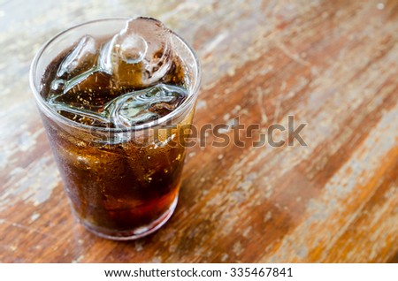 Soft Focus Cola with Ice in Glass on Wooden Table Blurred Background